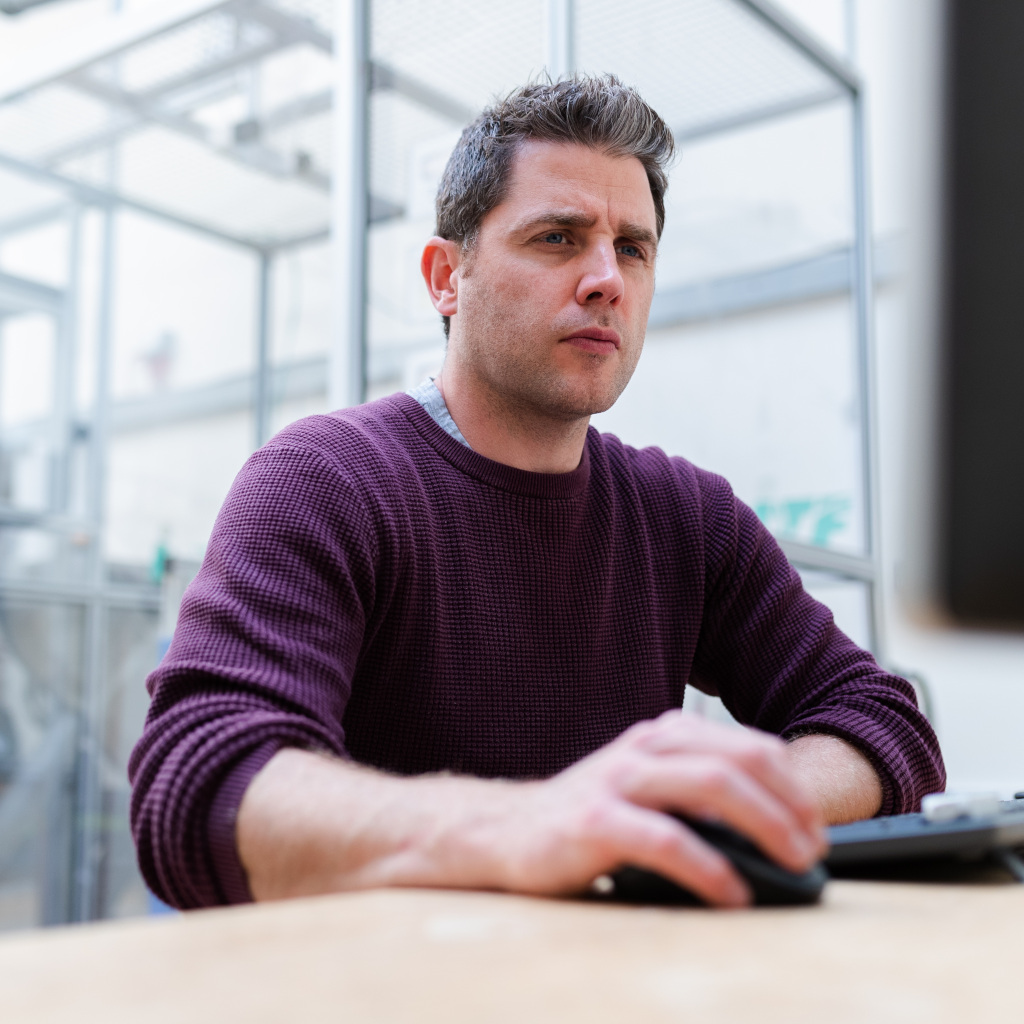 Engineer looking confused or sad using computer mouse